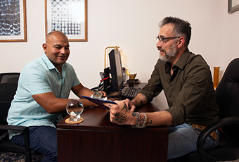 Two males talking at desk