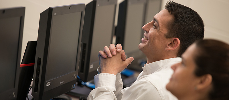 Female smiling sitting in front of computer