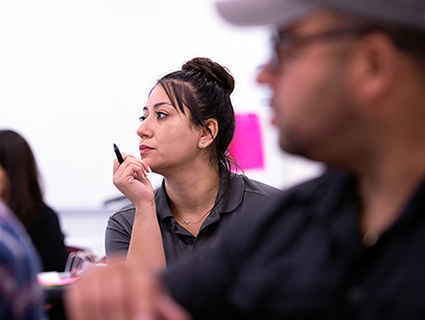 Female sitting in class with pen in her hand